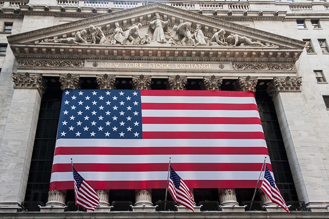 Façade of New York Stock Exchange with American flags on display