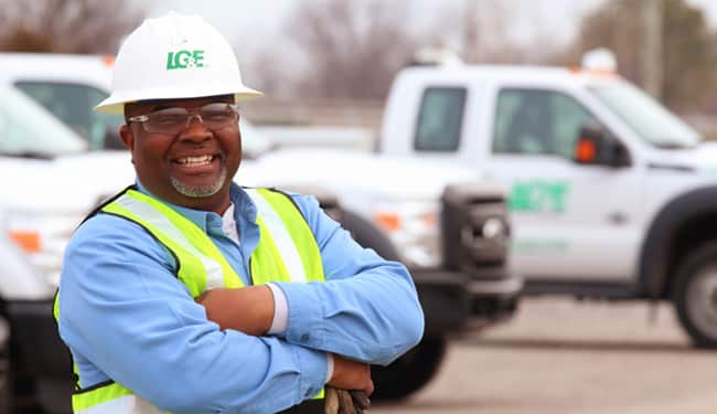 A utility worker in front of trucks