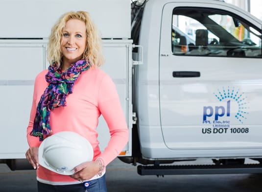 Woman standing next to ppl utility truck