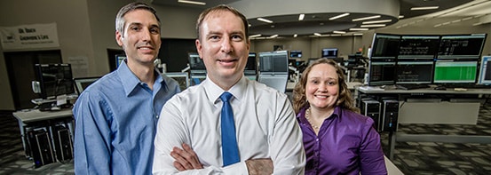 Kim Gaunter, Steve Gelatko and Jim Liero stand in a room with technical equipment