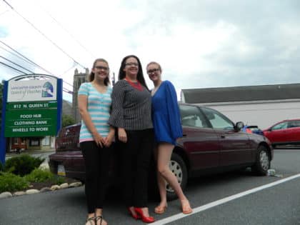 Katrina Smith, pictured with her two daughters stands in front of her new maroon Toyota Camry provided by the Lancaster County council of churches