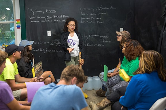 Teens debating in front of blackboard in LEAF classroom