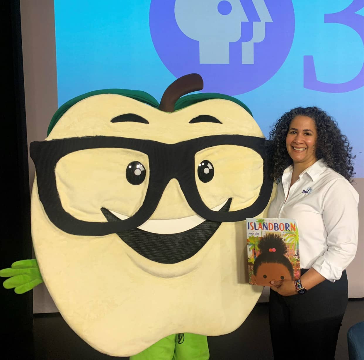 Lissette Santana and Cory the mascot from Lehigh Valley Reads posing with the book they read virtually for children