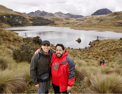 Young hispanic man and father pose in front of lake and mountains in Ecuador