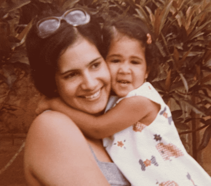 Young Hispanic mom hugs young daughter circa 1980s