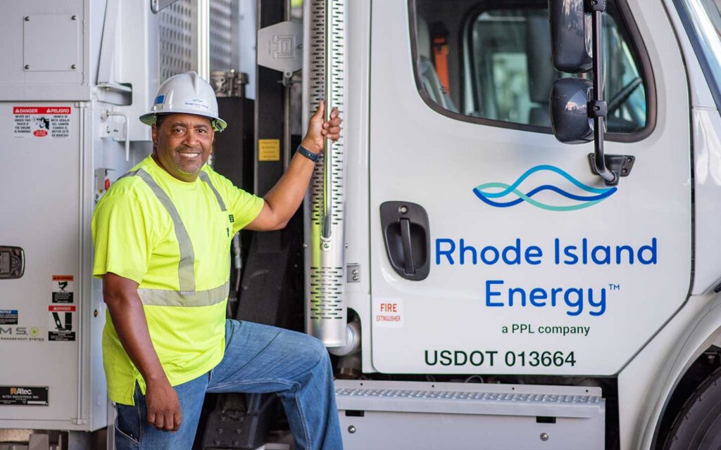 Rhode island energy worker standing next to a truck.